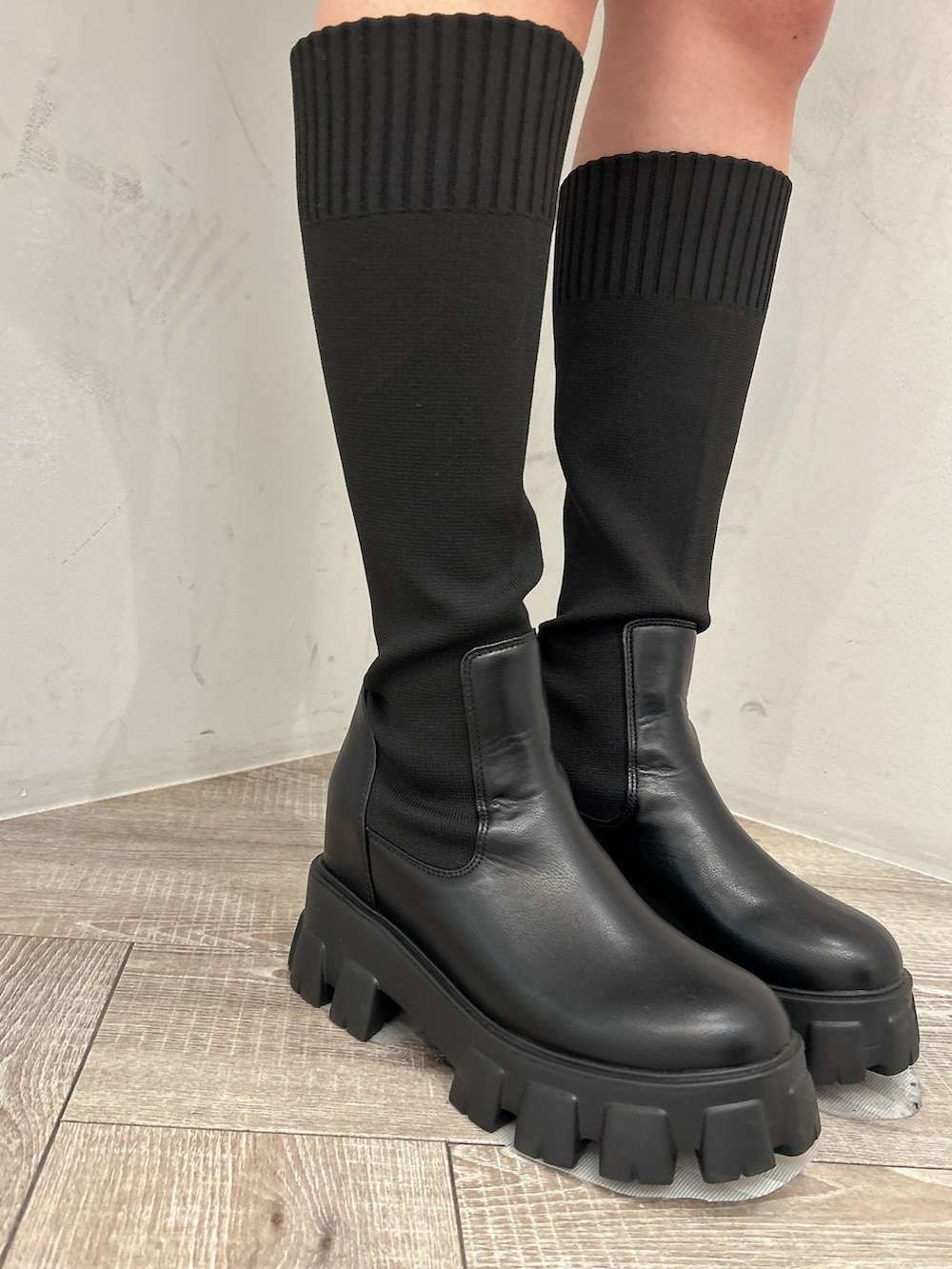 ベージュ系のニット/セーター、ブラック系のスカート、ブラック系のブーツを着用したレディースの秋コーディネートの7枚目の写真