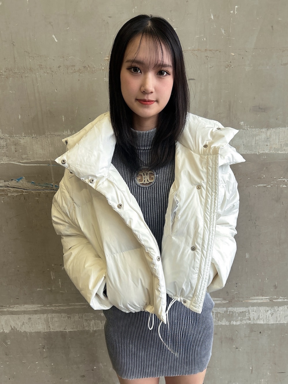 ブルー系のワンピース、ホワイト系のダウンジャケット/コート、ブラック系のブーツを着用したレディースの冬コーディネートの3枚目の写真