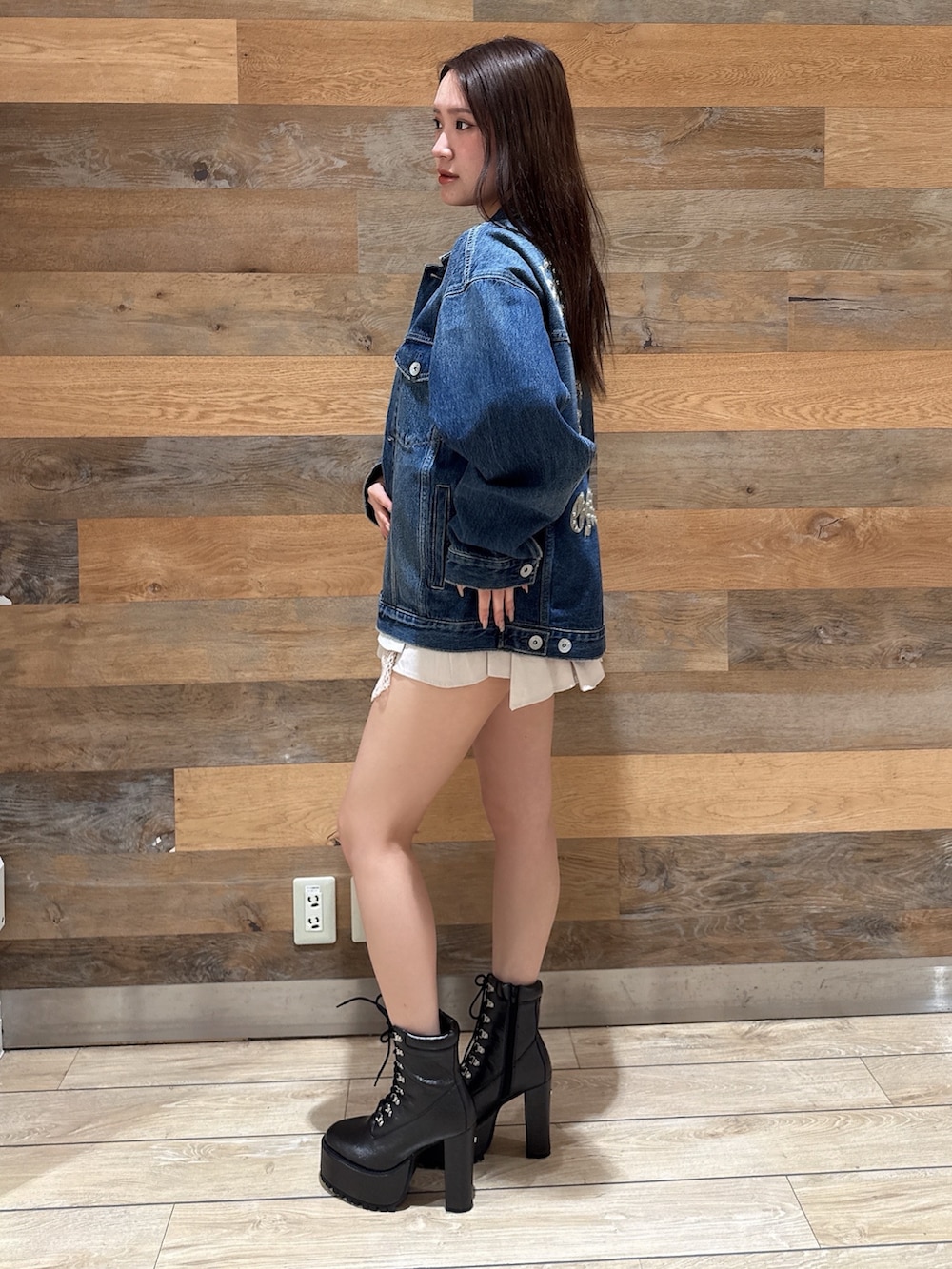 ブルー系のデニムジャケット、ブラック系のTシャツ/カットソー、ホワイト系のスカートを着用したレディースの春コーディネートの2枚目の写真