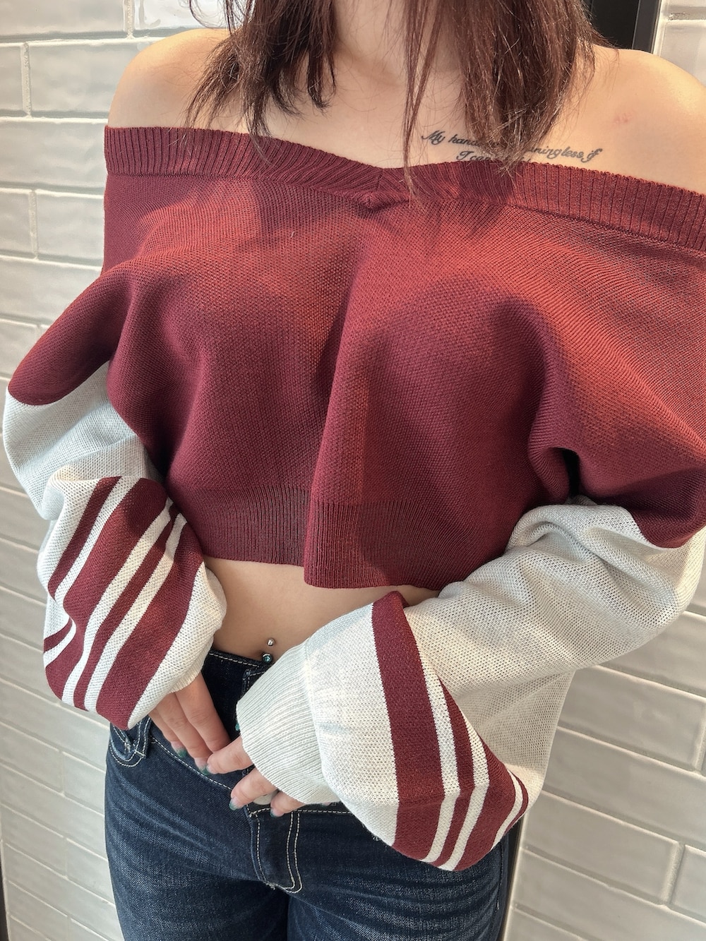 ブルー系のデニムパンツ、レッド系のニット/セーター、ブラック系のブーツを着用したレディースの秋コーディネートの6枚目の写真