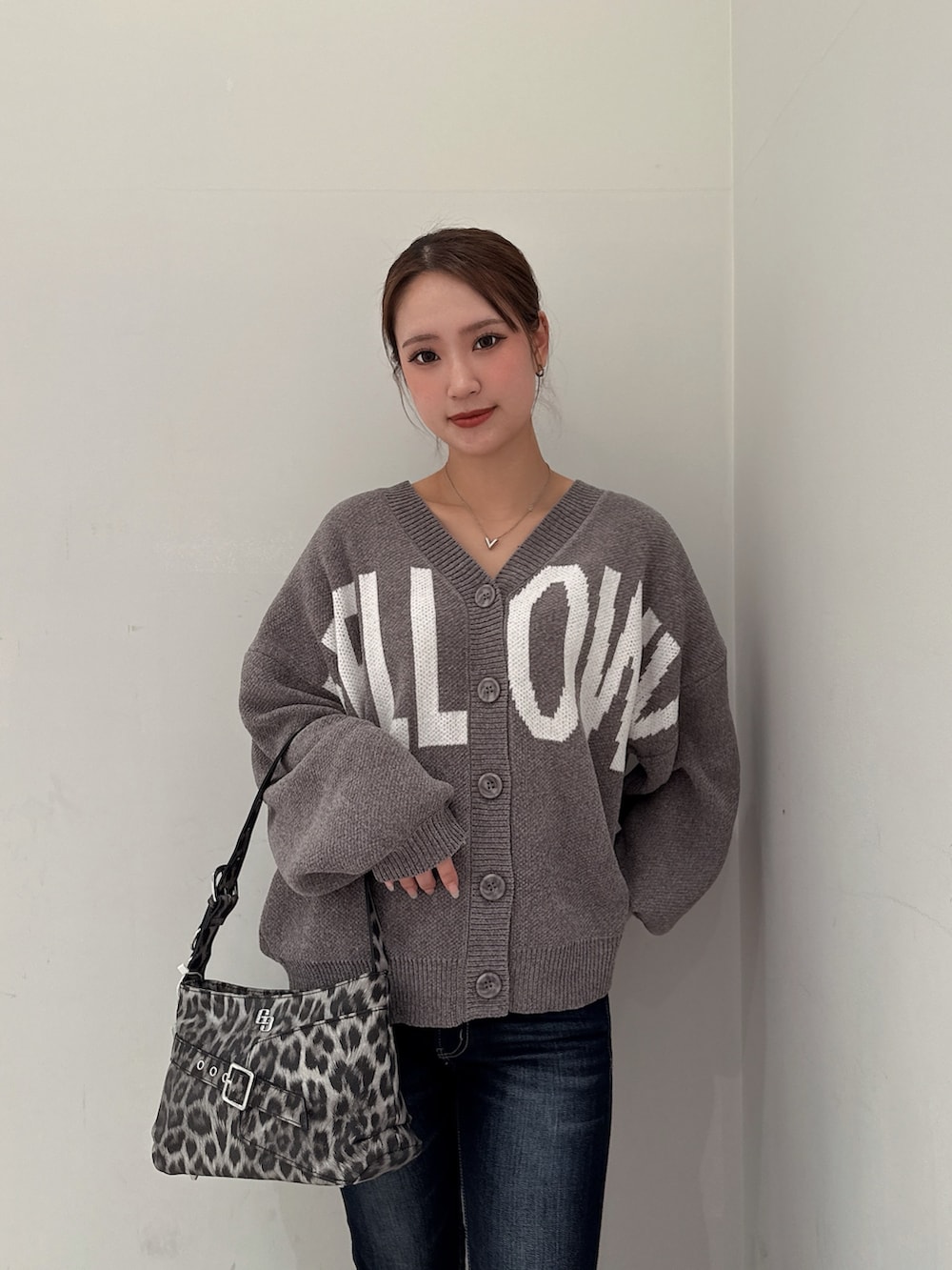 グレー系のカーディガン/ボレロ、ブラック系のブーツ、ブルー系のデニムパンツを着用したレディースの冬コーディネートの4枚目の写真