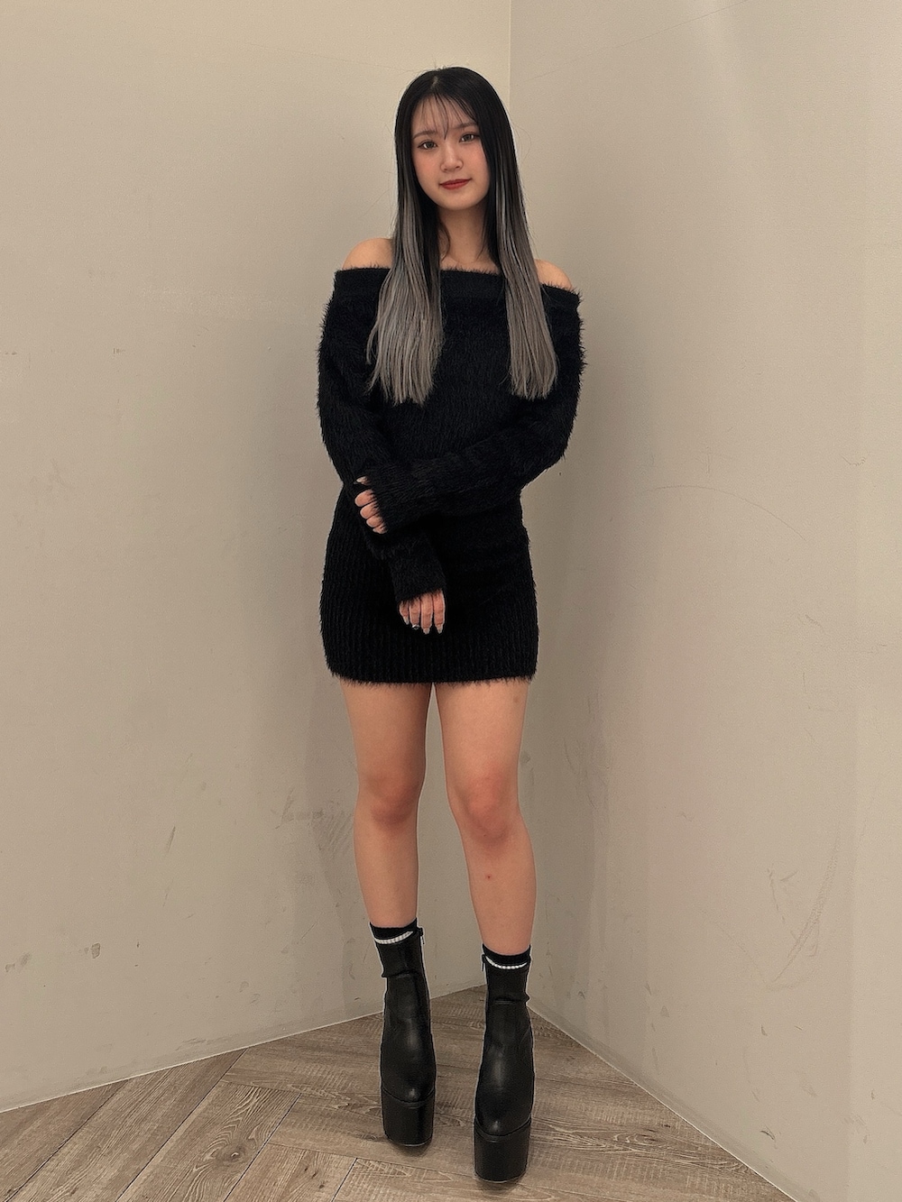 ブラック系のダウンジャケット/コート、ブラック系のワンピース、ブラック系のブーツを着用したレディースの秋コーディネートの3枚目の写真