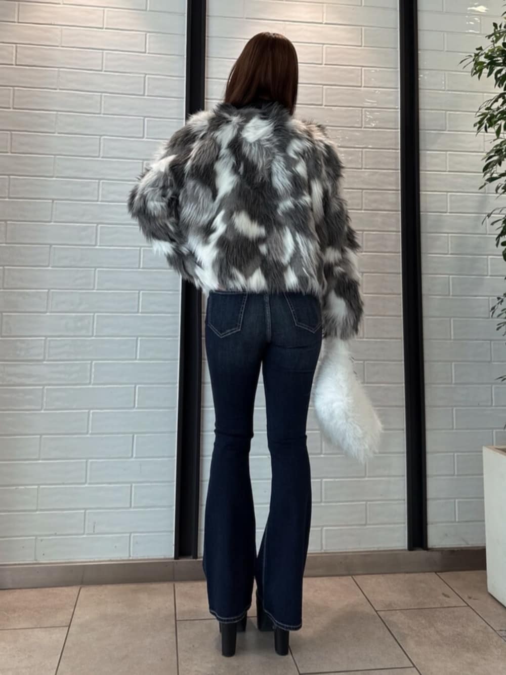 ブラック系のブーツ、ホワイト系のニット/セーター、その他のライダースジャケットを着用したレディースの冬コーディネートの3枚目の写真