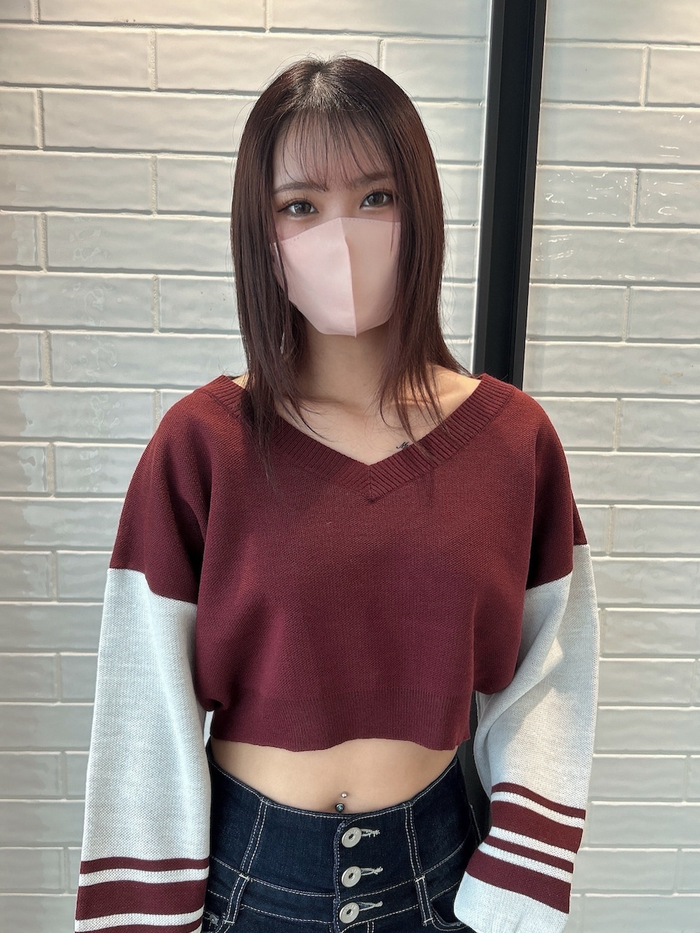 ブルー系のデニムパンツ、レッド系のニット/セーター、ブラック系のブーツを着用したレディースの秋コーディネートの2枚目の写真