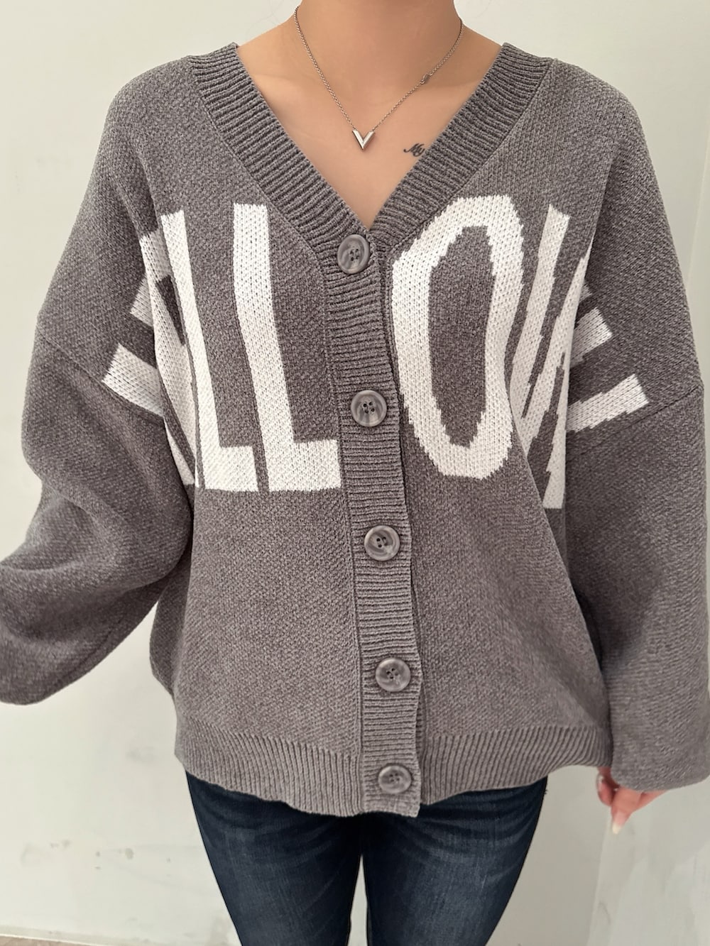 グレー系のカーディガン/ボレロ、ブラック系のブーツ、ブルー系のデニムパンツを着用したレディースの冬コーディネートの7枚目の写真