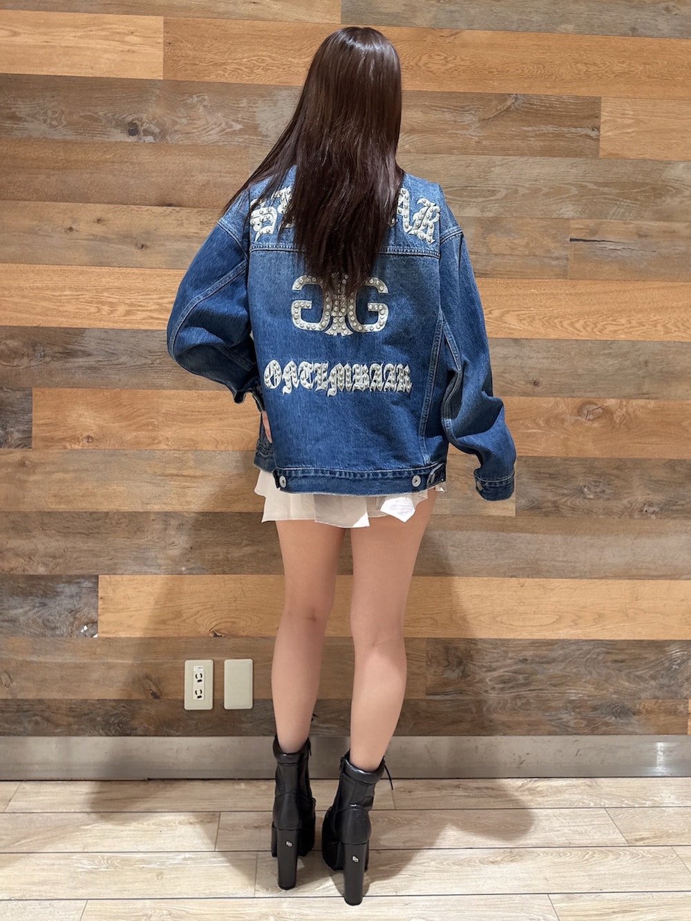 ブルー系のデニムジャケット、ブラック系のTシャツ/カットソー、ホワイト系のスカートを着用したレディースの春コーディネートの3枚目の写真