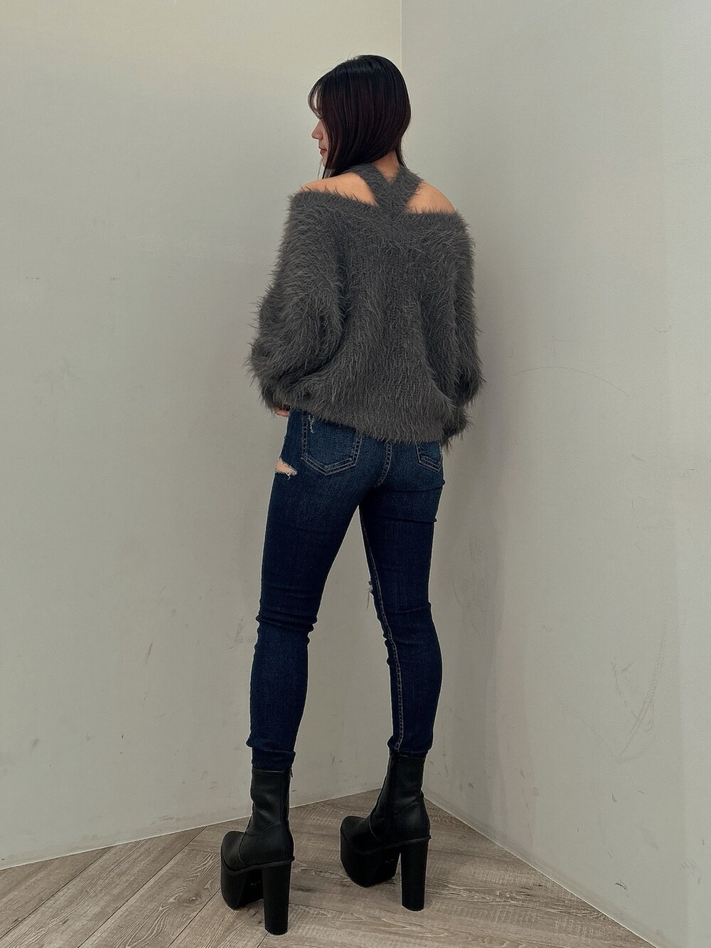 ブルー系のデニムパンツ、ブラック系のブーツ、グレー系のニット/セーターを着用したレディースの秋コーディネートの6枚目の写真