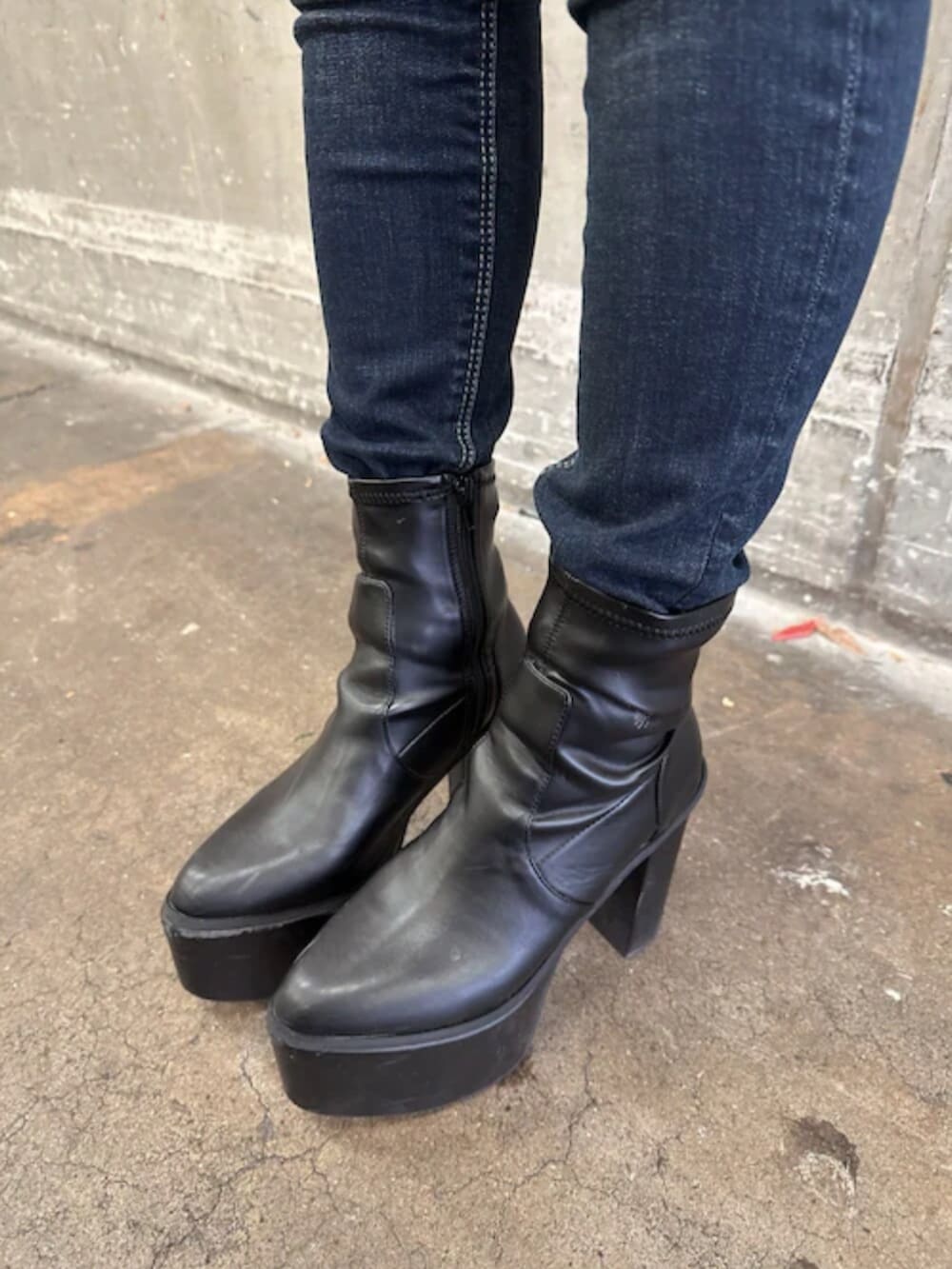 ブラック系のブーツ、ホワイト系のニット/セーター、その他のライダースジャケットを着用したレディースの冬コーディネートの7枚目の写真