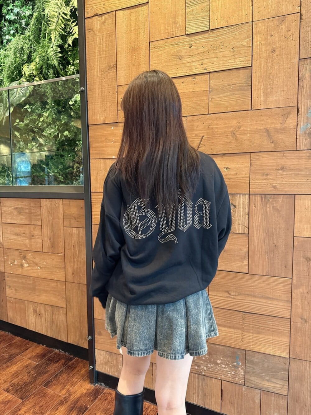 ブルー系のデニムスカート、ブラック系のブーツ、ブラック系のパーカーを着用したレディースの秋コーディネートの6枚目の写真