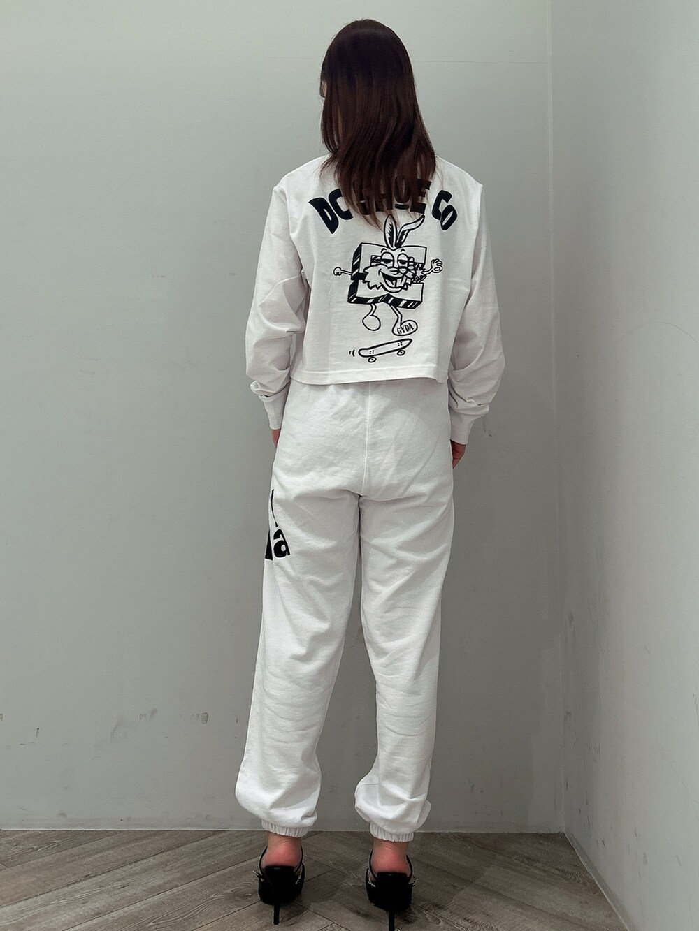 ホワイト系のTシャツ/カットソー、ホワイト系のスウェットパンツ、ブラック系のパンプスを着用したレディースの春コーディネートの3枚目の写真
