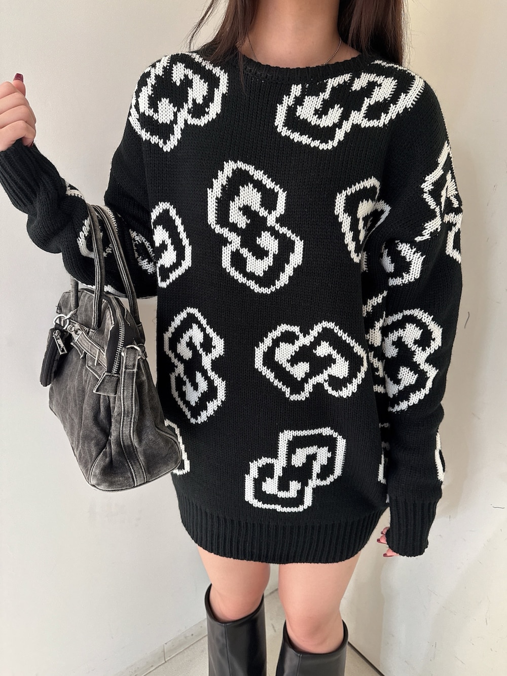 ブラック系のニット/セーター、ブラック系のスカート、ブラック系のブーツを着用したレディースの秋コーディネートの8枚目の写真