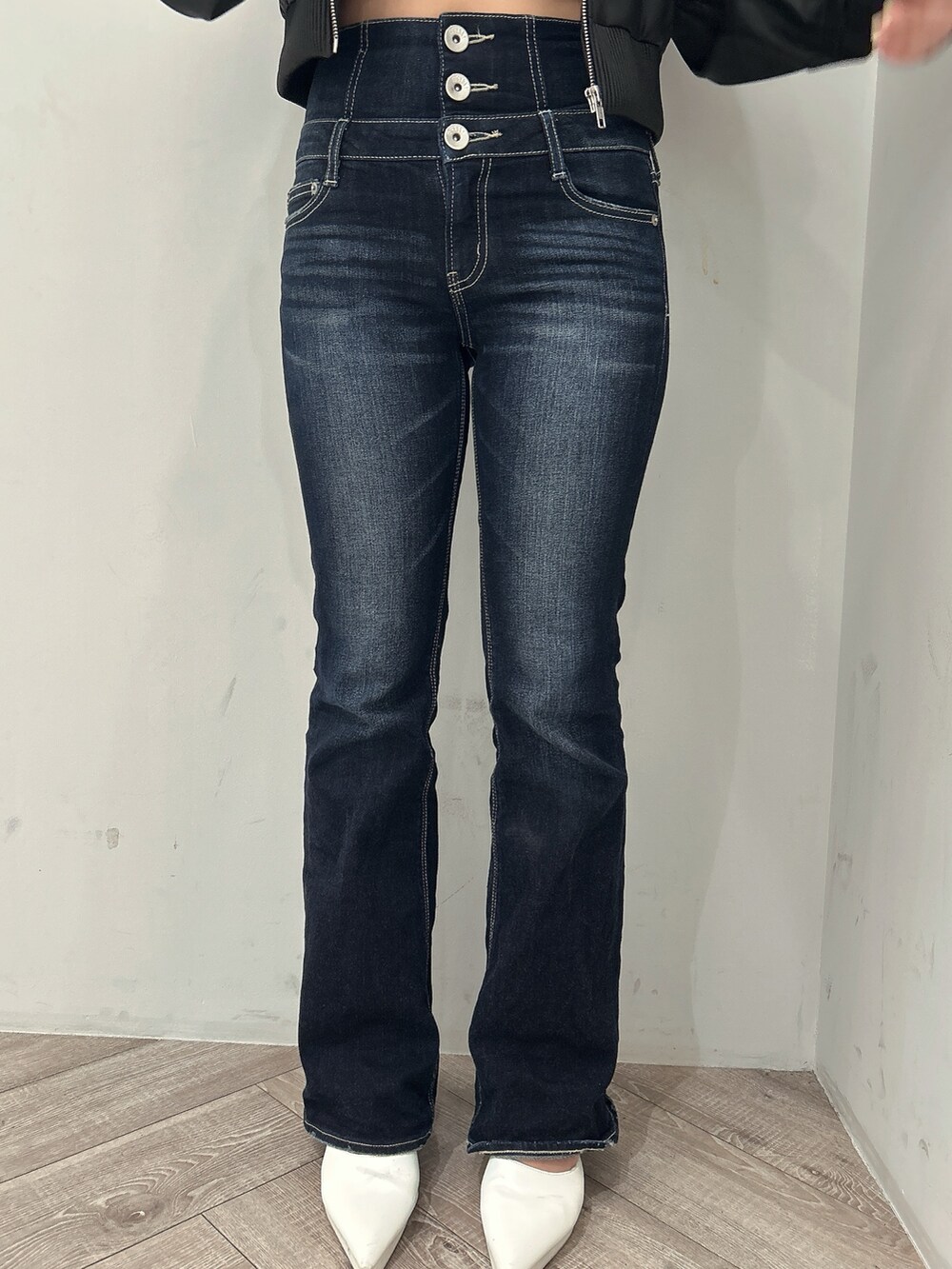 ブラック系のニット/セーター、ブラック系のブルゾン、ブルー系のデニムパンツを着用したレディースの春コーディネートの9枚目の写真