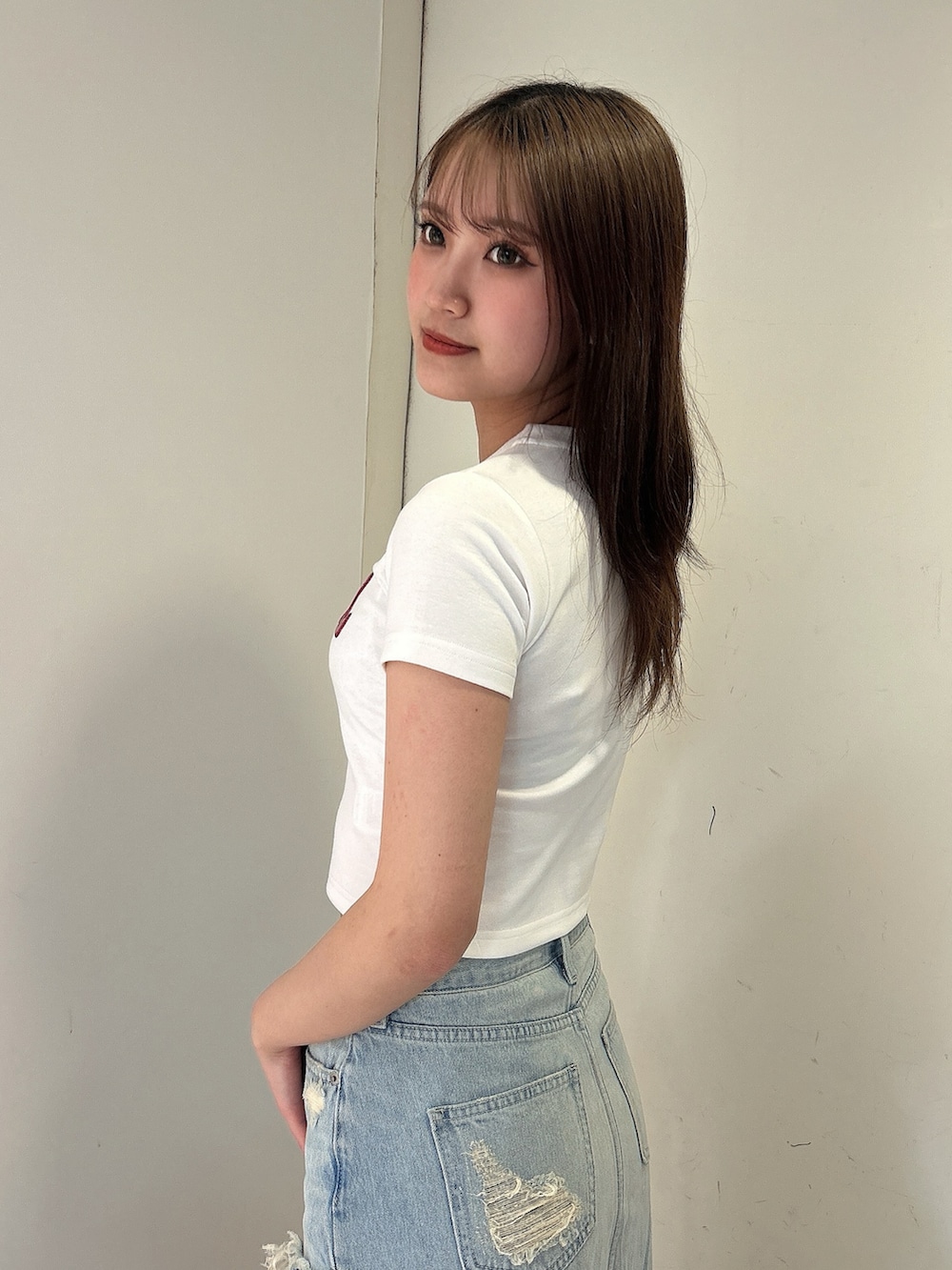 ホワイト系のTシャツ/カットソー、ブルー系のデニムスカート、ホワイト系のサンダルを着用したレディースの春コーディネートの5枚目の写真