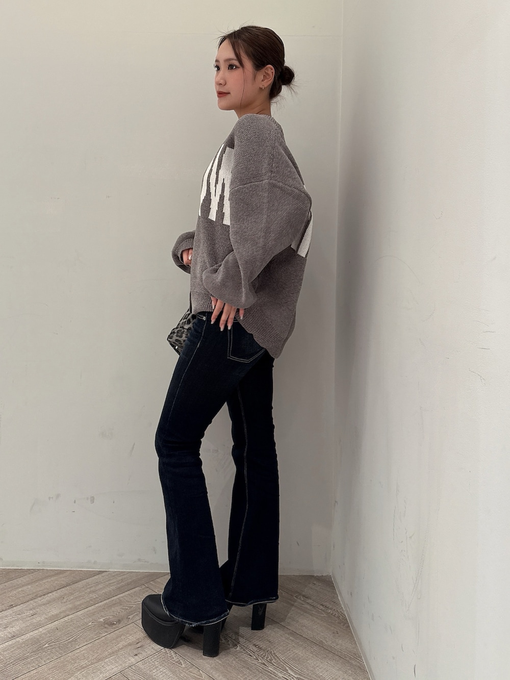 グレー系のカーディガン/ボレロ、ブラック系のブーツ、ブルー系のデニムパンツを着用したレディースの冬コーディネートの2枚目の写真