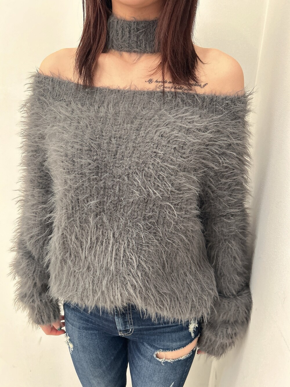ブルー系のデニムパンツ、ブラック系のブーツ、グレー系のニット/セーターを着用したレディースの秋コーディネートの3枚目の写真