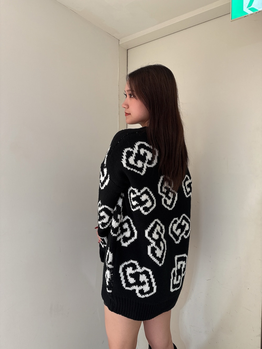 ブラック系のニット/セーター、ブラック系のスカート、ブラック系のブーツを着用したレディースの秋コーディネートの4枚目の写真