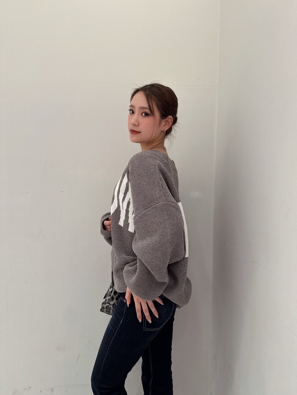 グレー系のカーディガン/ボレロ、ブラック系のブーツ、ブルー系のデニムパンツを着用したレディースの冬コーディネートの5枚目の写真