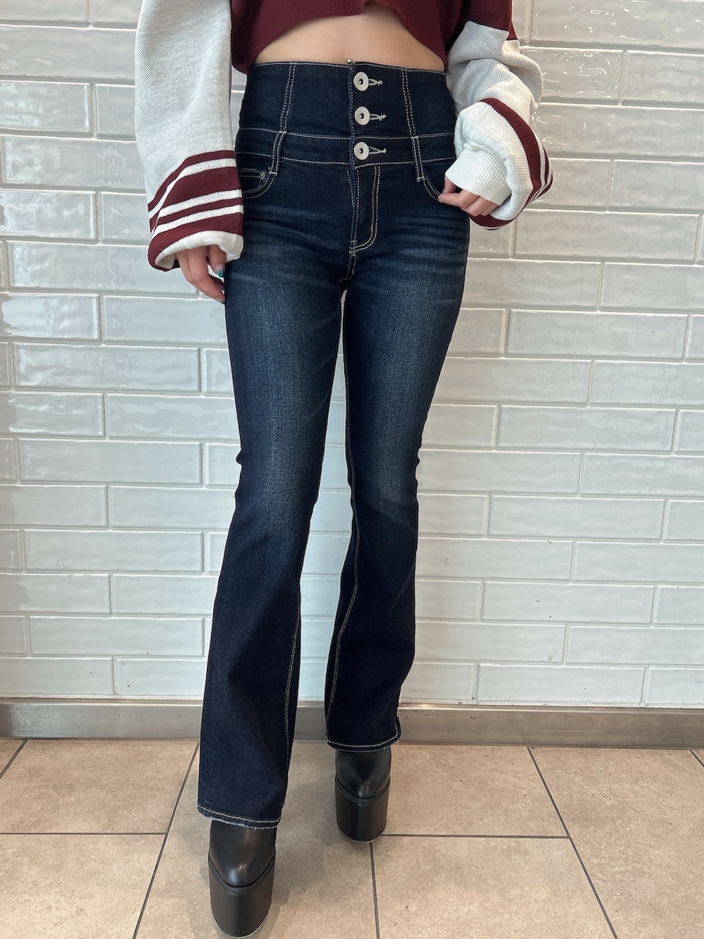 ブルー系のデニムパンツ、レッド系のニット/セーター、ブラック系のブーツを着用したレディースの秋コーディネートの7枚目の写真