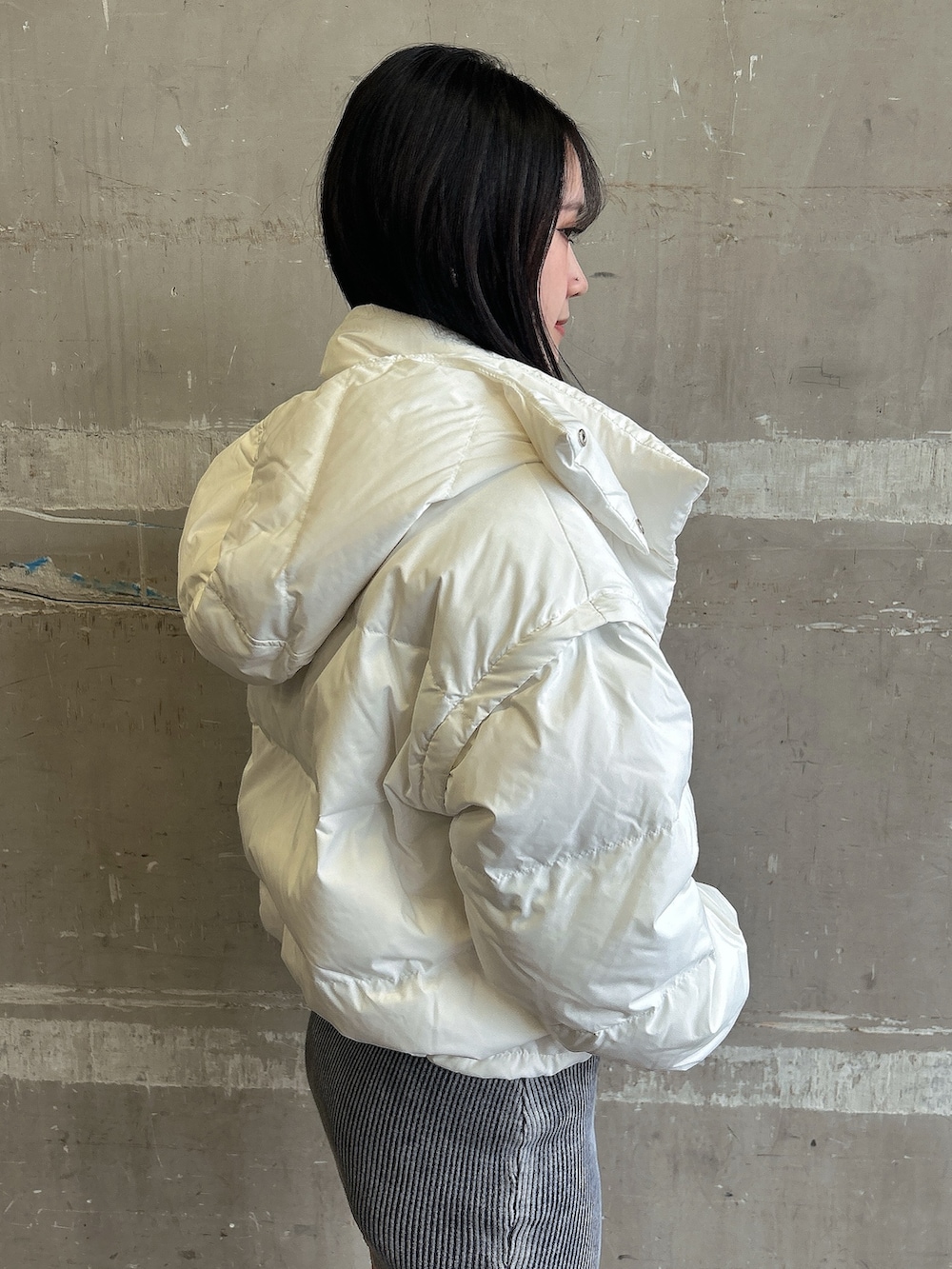 ブルー系のワンピース、ホワイト系のダウンジャケット/コート、ブラック系のブーツを着用したレディースの冬コーディネートの5枚目の写真