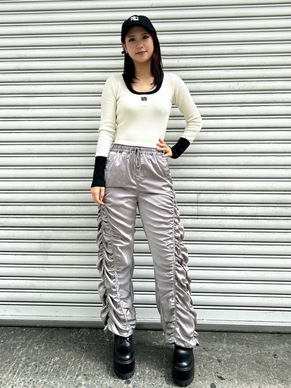 グレー系のその他パンツ、ブラック系のベスト、ホワイト系のニット/セーターを着用したレディースの秋コーディネートの3枚目の写真