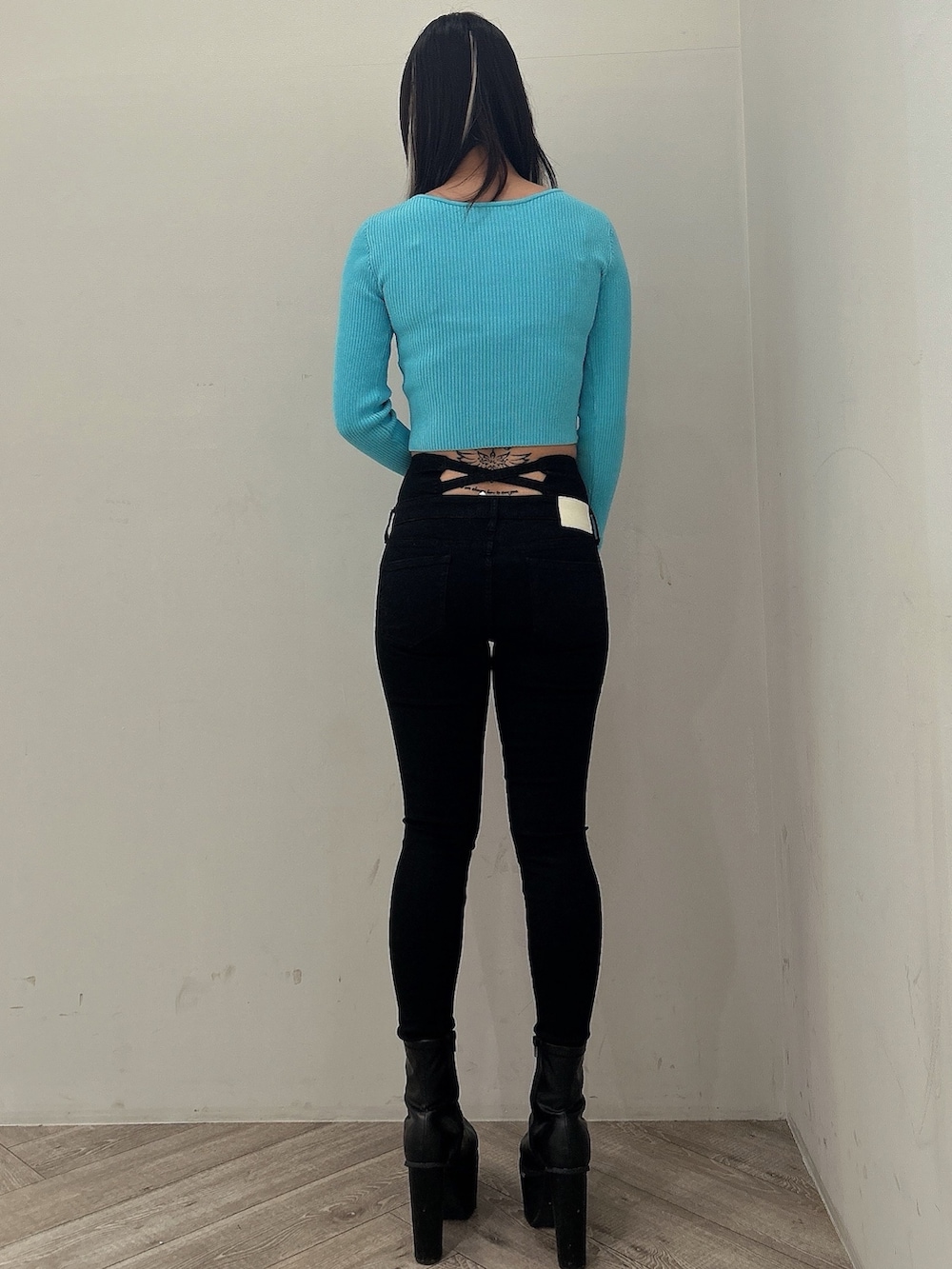 ブルー系のニット/セーター、ブラック系のデニムパンツ、ブラック系のブーツを着用したレディースの冬コーディネートの4枚目の写真