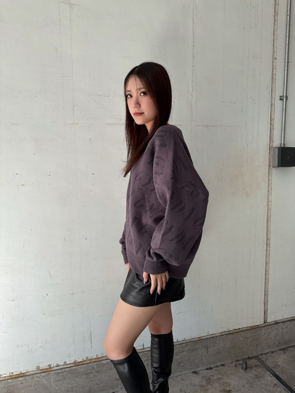 グレー系のニット/セーター、ブラック系のスカート、ブラック系のブーツを着用したレディースの秋コーディネートの5枚目の写真