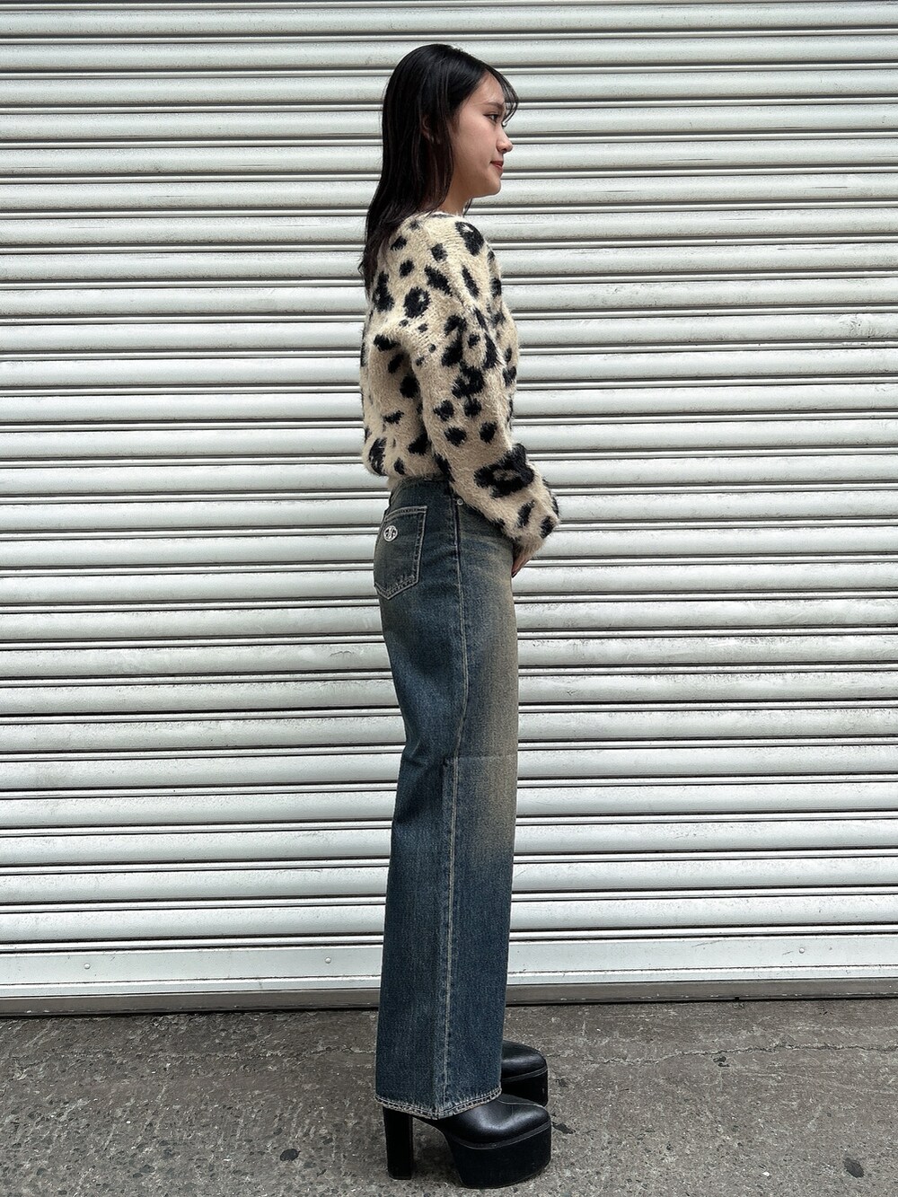 ホワイト系のニット/セーター、ブルー系のデニムパンツ、ブラック系のブーツを着用したレディースの冬コーディネートの4枚目の写真