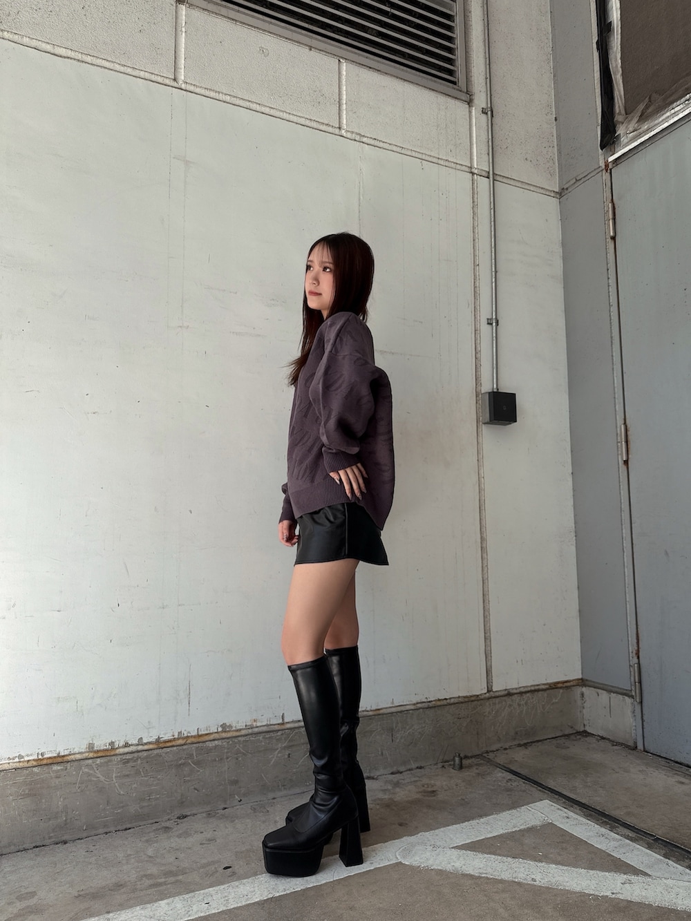 グレー系のニット/セーター、ブラック系のスカート、ブラック系のブーツを着用したレディースの秋コーディネートの2枚目の写真