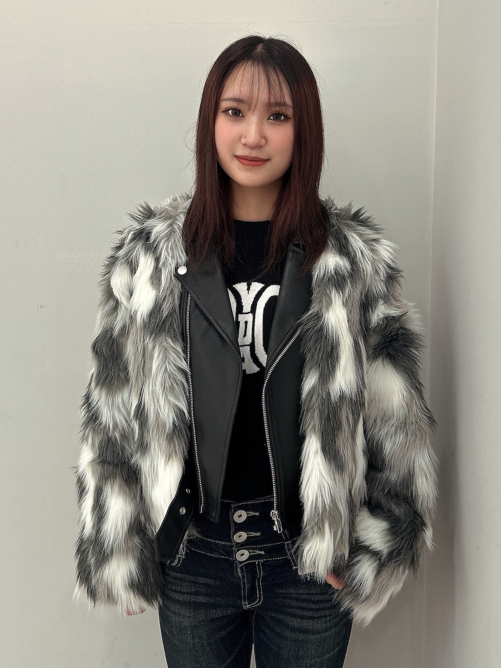 ブルー系のデニムパンツ、その他のライダースジャケット、ブラック系のニット/セーターを着用したレディースの秋コーディネートの2枚目の写真