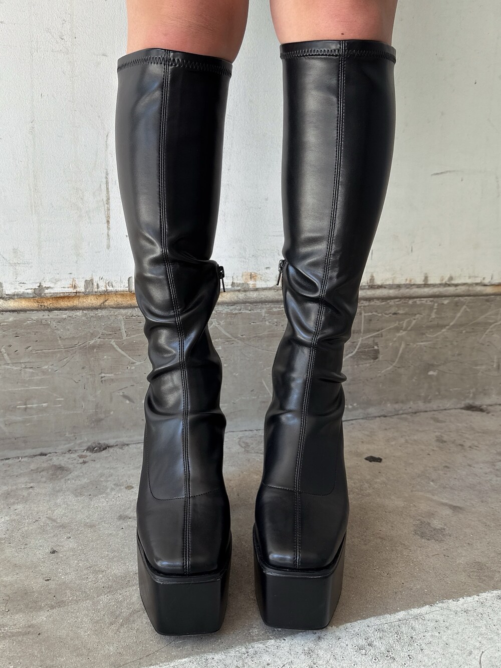 グレー系のニット/セーター、ブラック系のスカート、ブラック系のブーツを着用したレディースの秋コーディネートの8枚目の写真