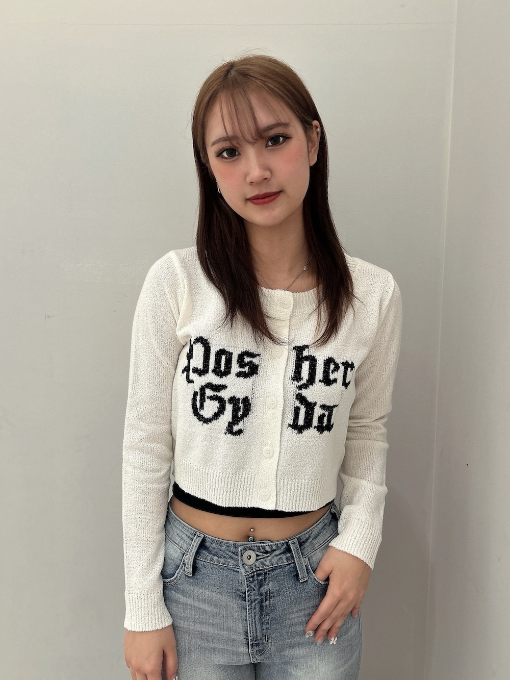 ホワイト系のカーディガン/ボレロ、ブラック系のキャミソール、ブルー系のデニムパンツを着用したレディースの春コーディネートの4枚目の写真