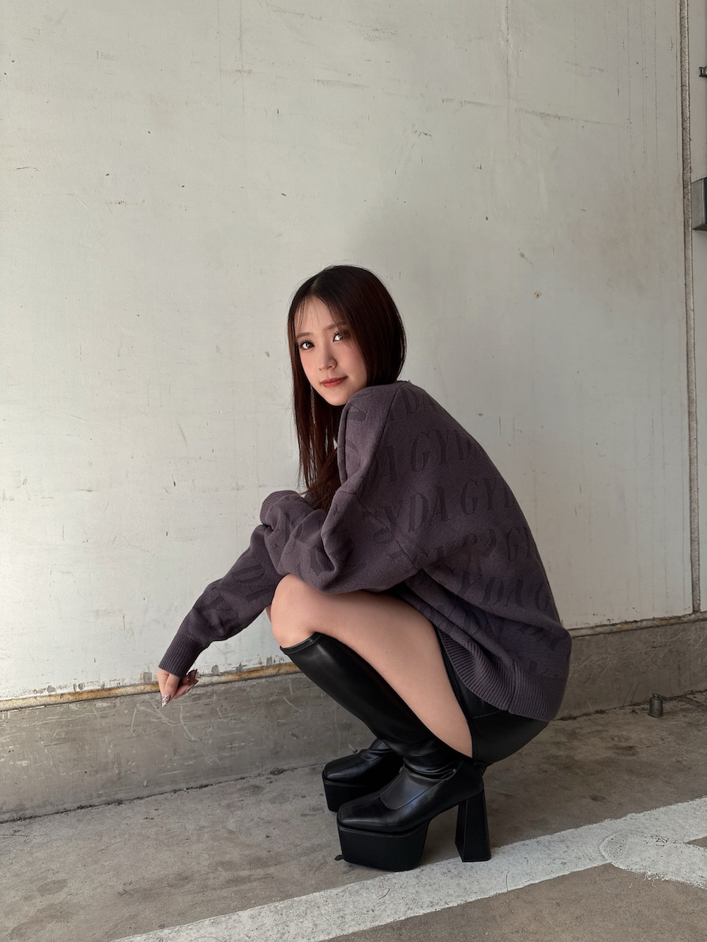 グレー系のニット/セーター、ブラック系のスカート、ブラック系のブーツを着用したレディースの秋コーディネートの7枚目の写真