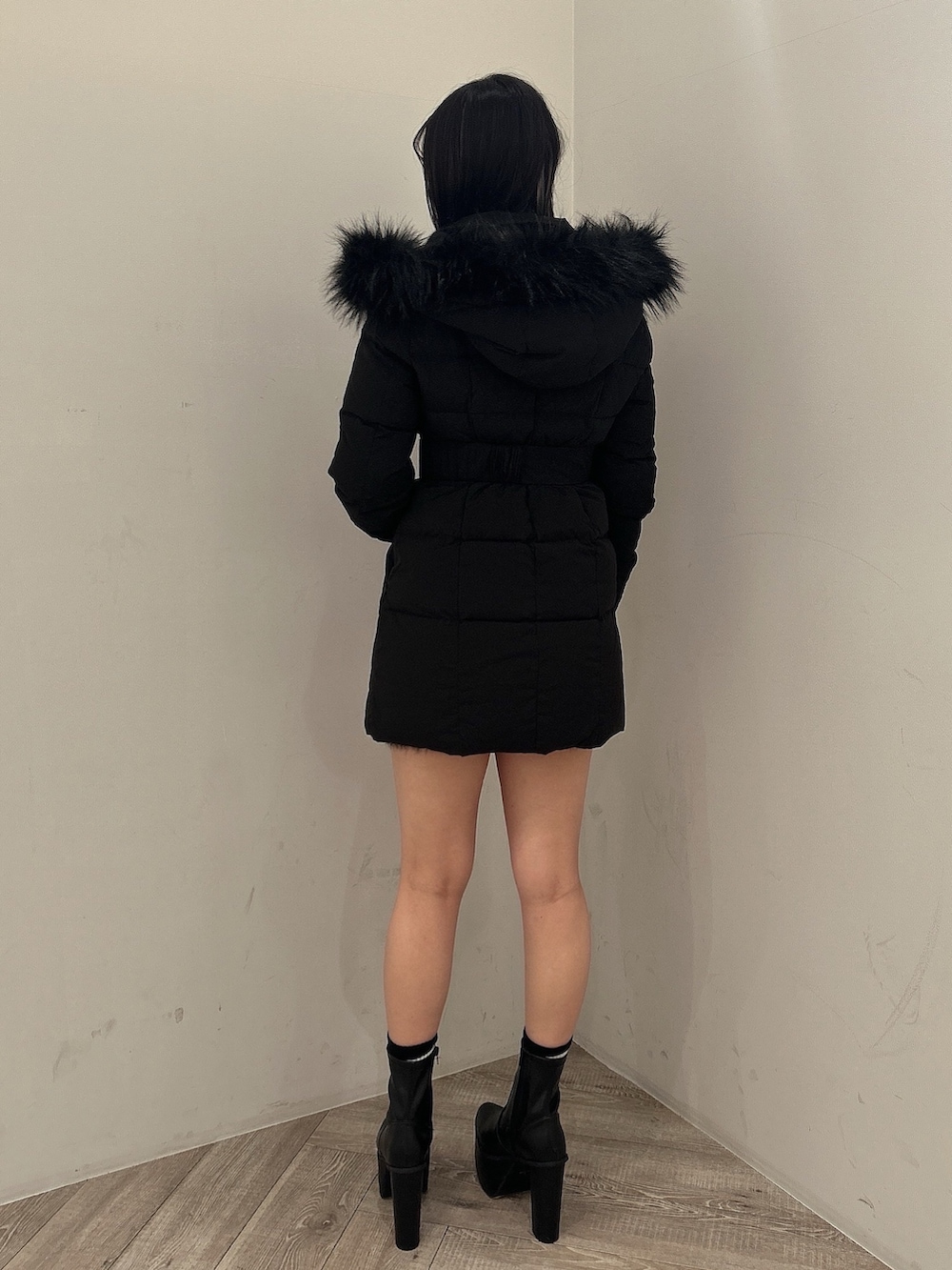 ブラック系のダウンジャケット/コート、ブラック系のワンピース、ブラック系のブーツを着用したレディースの秋コーディネートの5枚目の写真