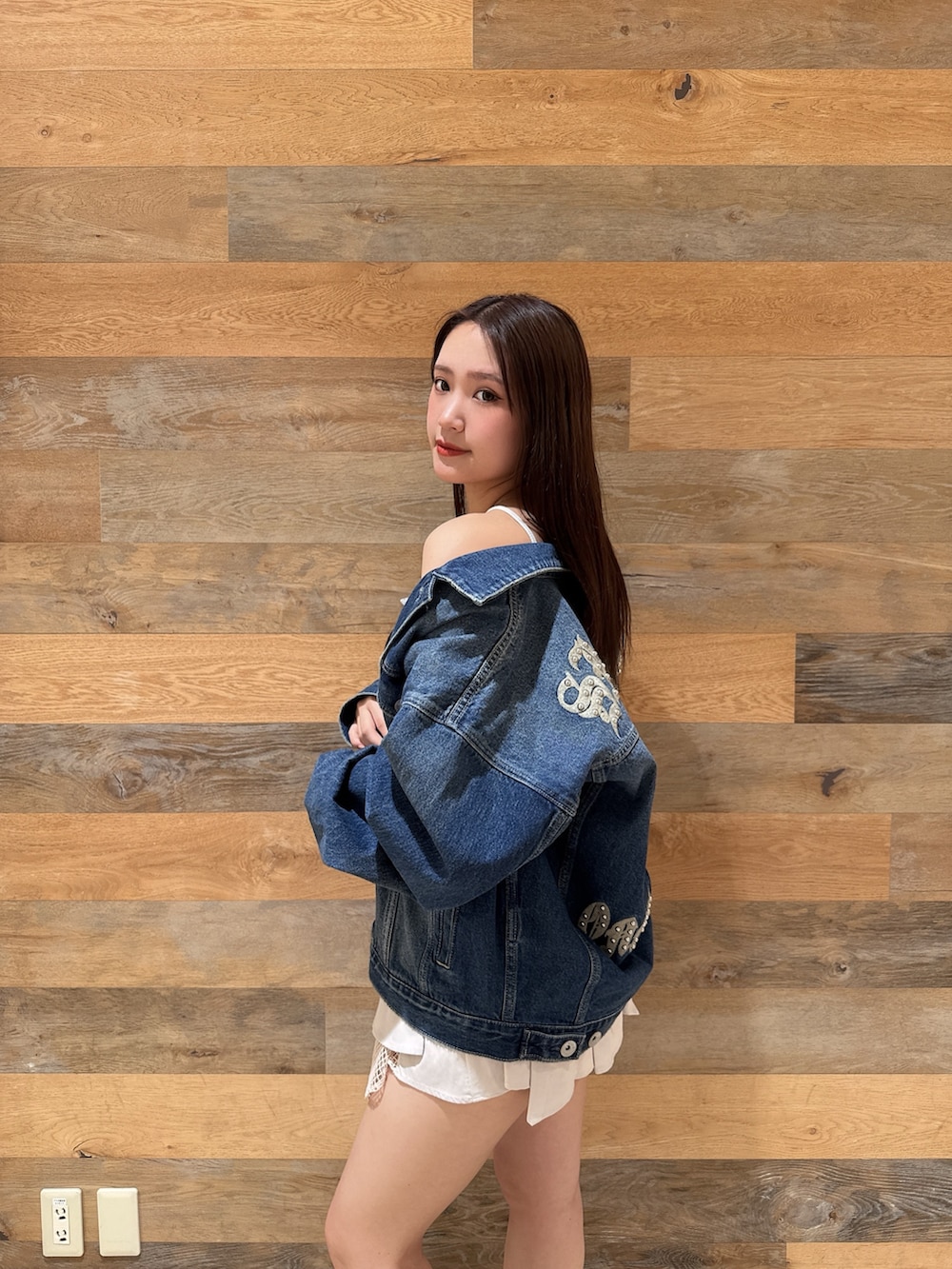 ブルー系のデニムジャケット、ブラック系のTシャツ/カットソー、ホワイト系のスカートを着用したレディースの春コーディネートの5枚目の写真