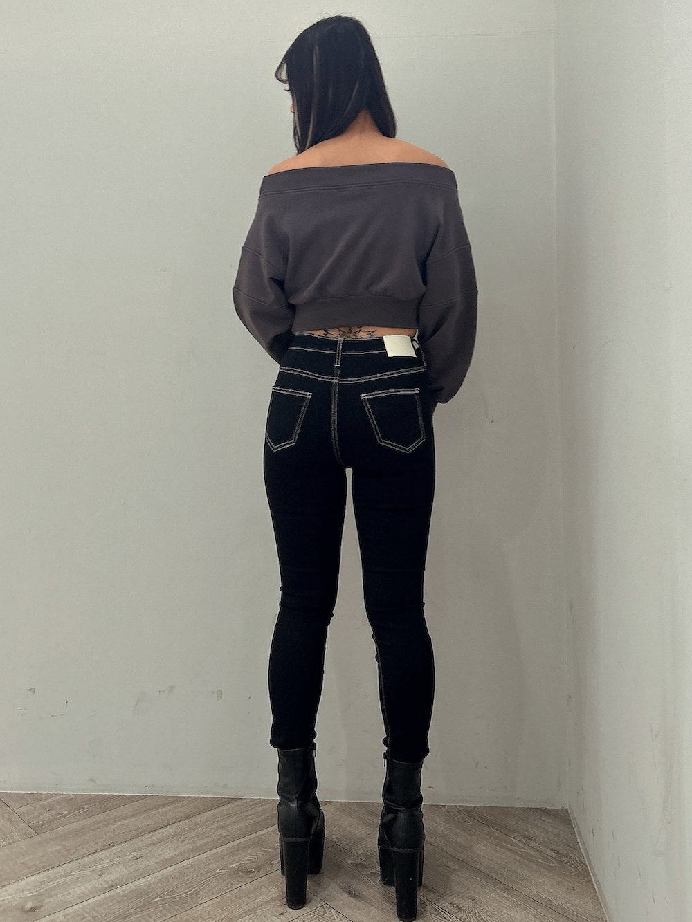 グレー系のスウェット、ブラック系のデニムパンツ、ブラック系のブーツを着用したレディースの冬コーディネートの3枚目の写真