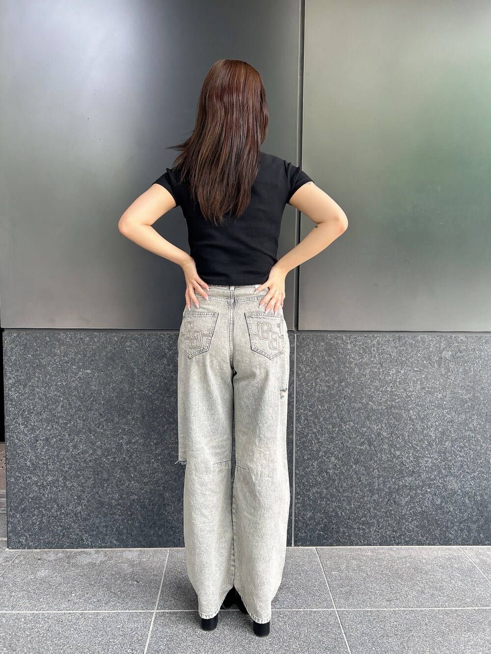 ブラック系のTシャツ/カットソー、ブルー系のデニムパンツ、ブラック系のサンダルを着用したレディースの夏コーディネートの3枚目の写真