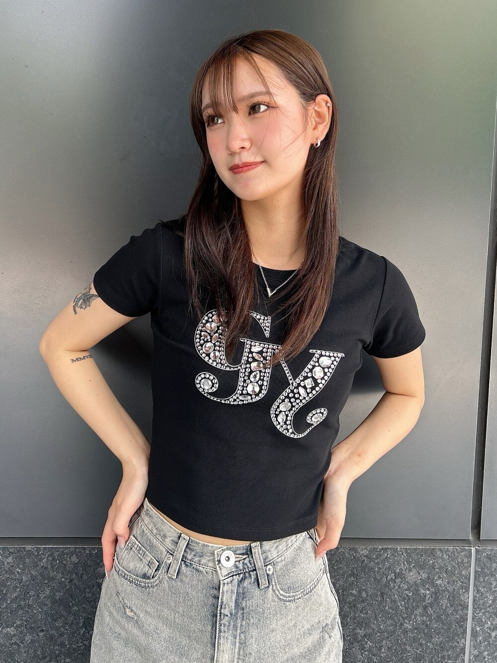 ブラック系のTシャツ/カットソー、ブルー系のデニムパンツ、ブラック系のサンダルを着用したレディースの夏コーディネートの4枚目の写真