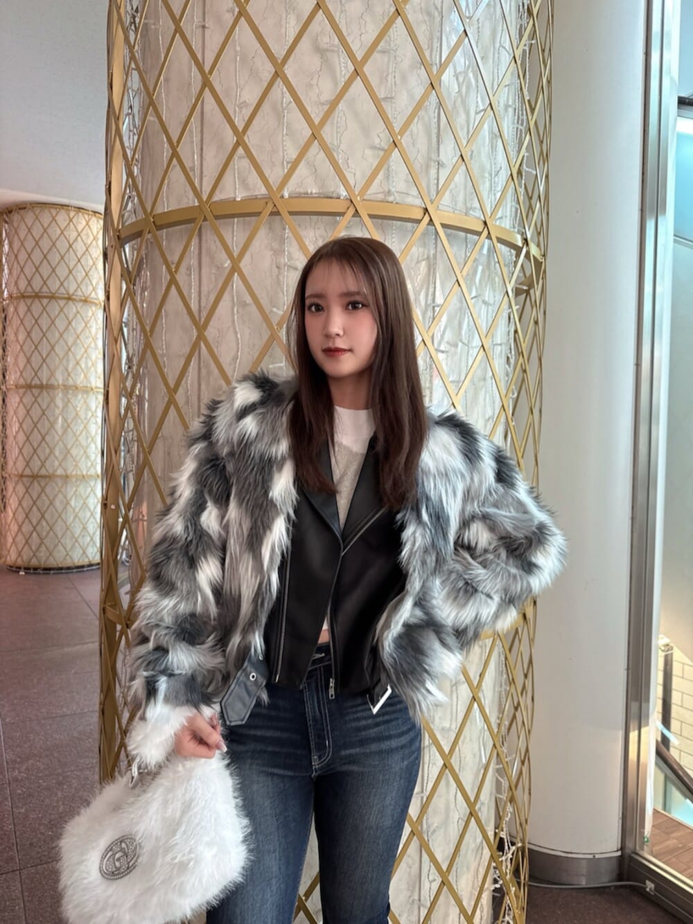 ブラック系のブーツ、ホワイト系のニット/セーター、その他のライダースジャケットを着用したレディースの冬コーディネートの4枚目の写真