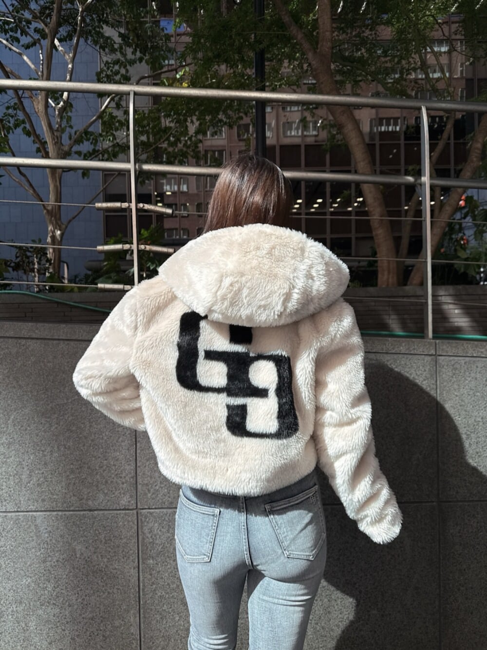 ブラック系のブーツ、ホワイト系のニット/セーター、ホワイト系のブルゾンを着用したレディースの秋コーディネートの6枚目の写真