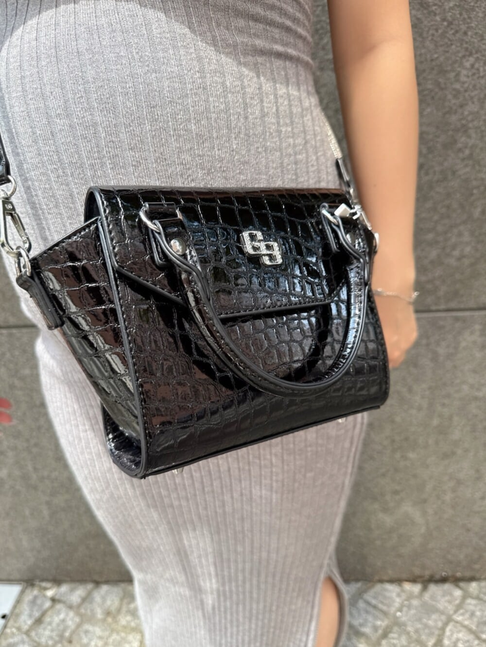 ブラック系のハンドバッグ、ブラック系のサンダル、グレー系のワンピースを着用したレディースの夏コーディネートの8枚目の写真