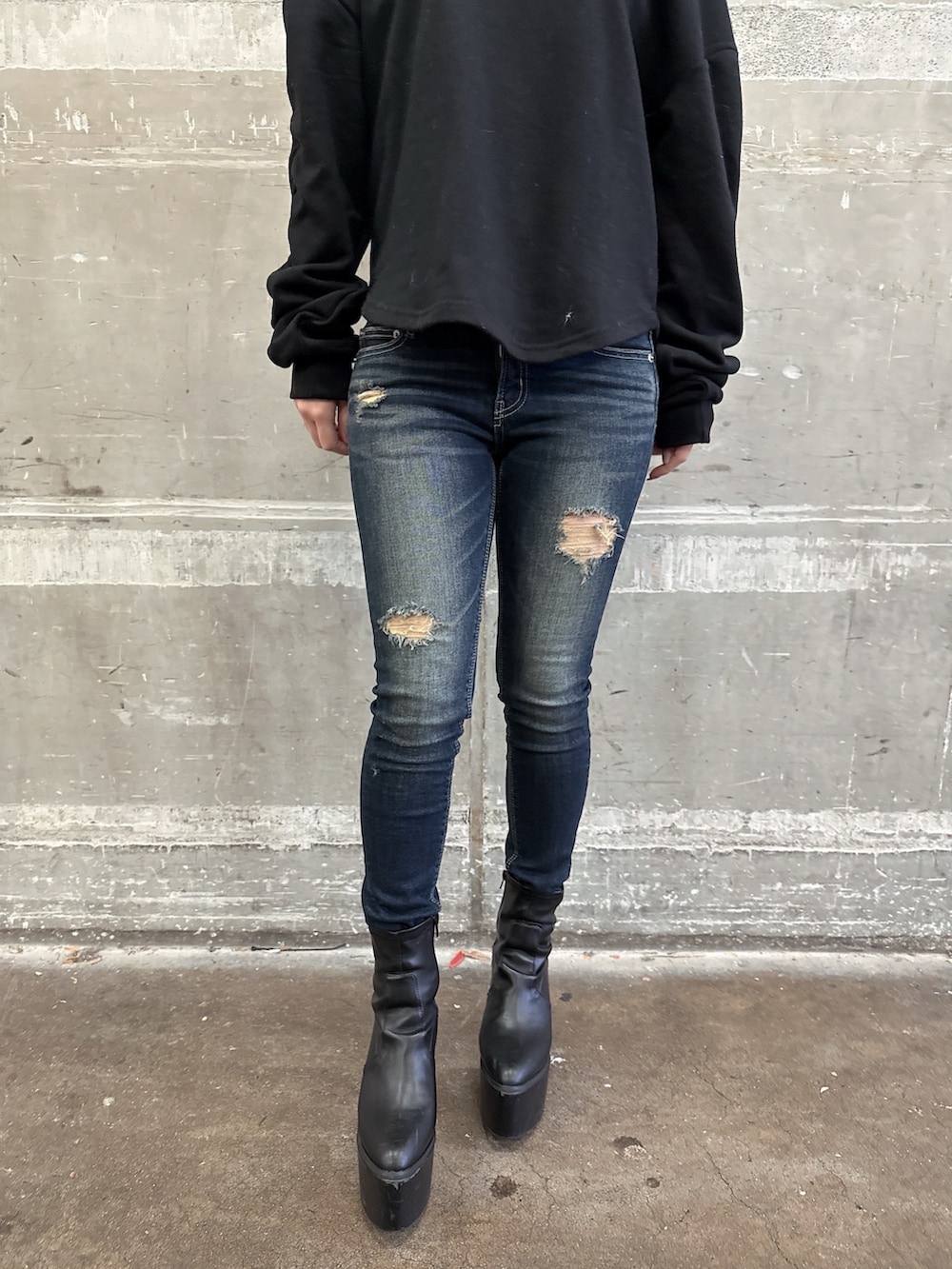 ブラック系のムートンコート、ブラック系のスウェット、ブルー系のデニムパンツを着用したレディースの秋コーディネートの8枚目の写真