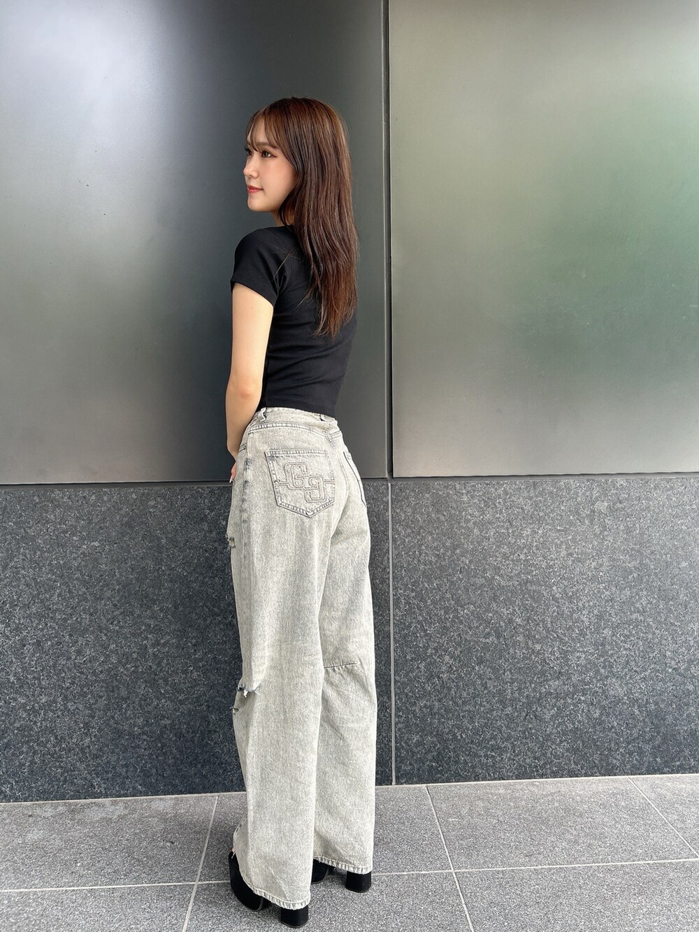 ブラック系のTシャツ/カットソー、ブルー系のデニムパンツ、ブラック系のサンダルを着用したレディースの夏コーディネートの2枚目の写真