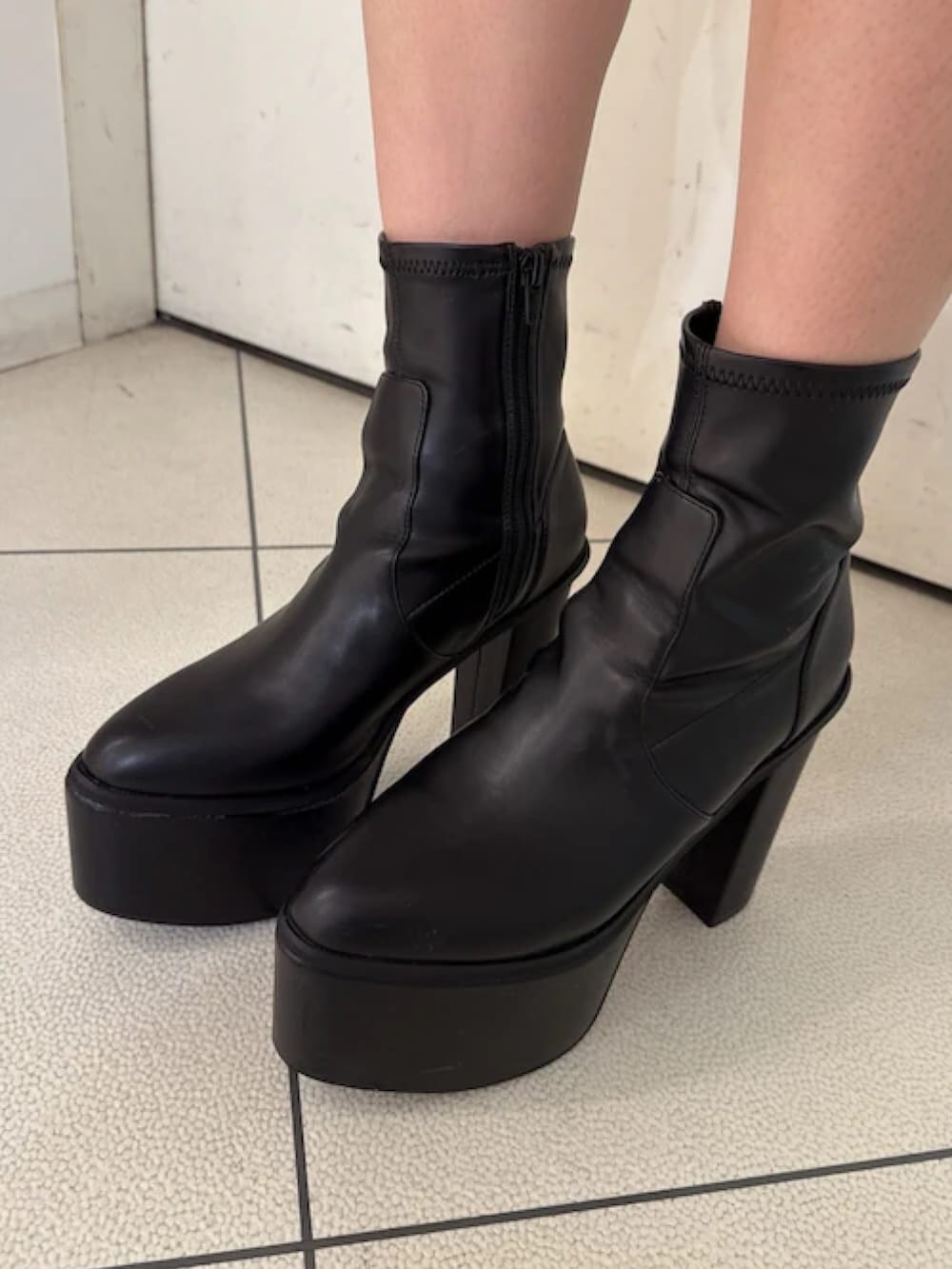 ブラック系のダウンジャケット/コート、ホワイト系のニット/セーター、ブルー系のデニムパンツを着用したレディースの秋コーディネートの7枚目の写真