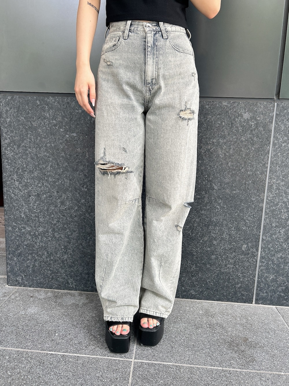 ブラック系のTシャツ/カットソー、ブルー系のデニムパンツ、ブラック系のサンダルを着用したレディースの夏コーディネートの8枚目の写真