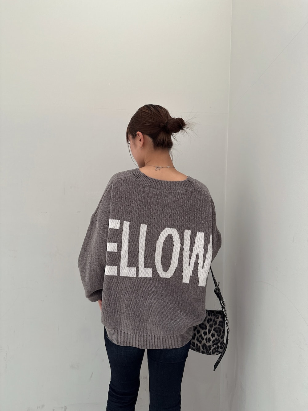 グレー系のカーディガン/ボレロ、ブラック系のブーツ、ブルー系のデニムパンツを着用したレディースの冬コーディネートの6枚目の写真