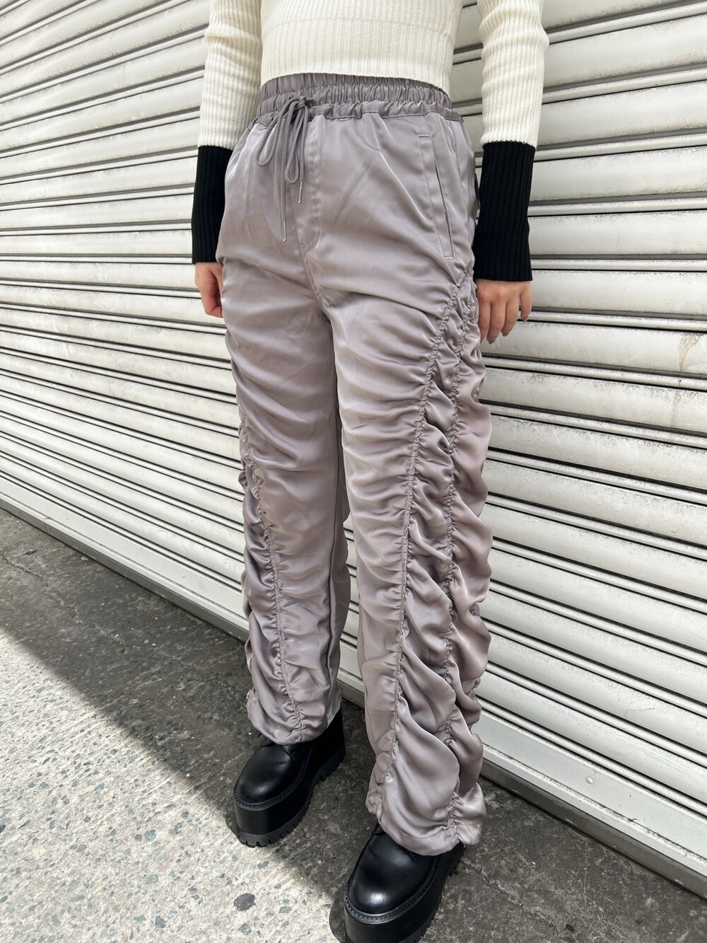 グレー系のその他パンツ、ブラック系のベスト、ホワイト系のニット/セーターを着用したレディースの秋コーディネートの6枚目の写真