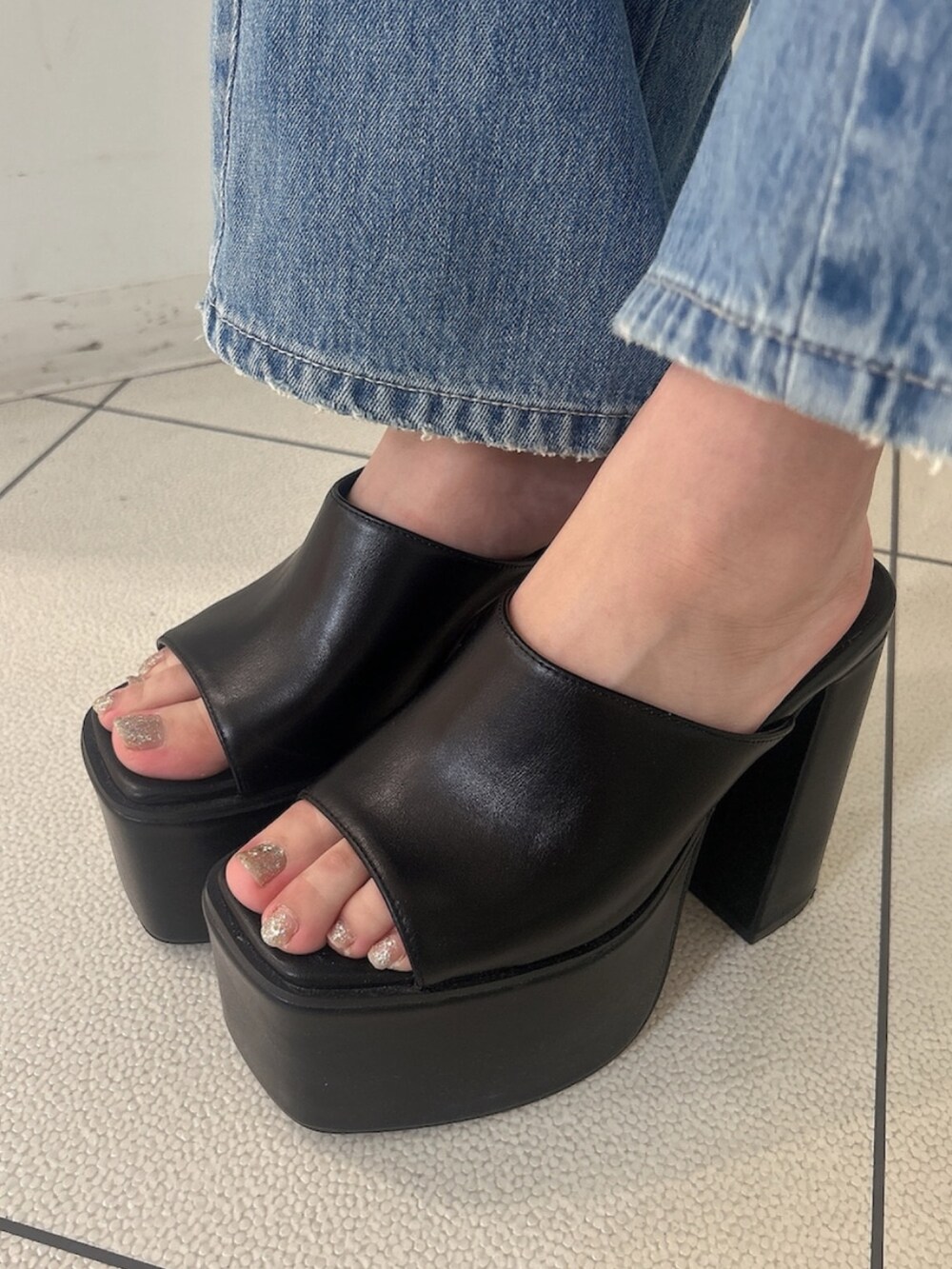 ブラック系のTシャツ/カットソー、ブルー系のデニムパンツ、ブラック系のサンダルを着用したレディースの夏コーディネートの9枚目の写真