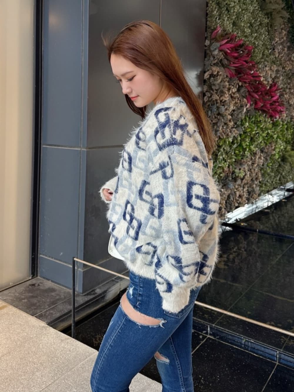 ブラック系のブーツ、ホワイト系のニット/セーター、ブルー系のデニムパンツを着用したレディースの冬コーディネートの5枚目の写真