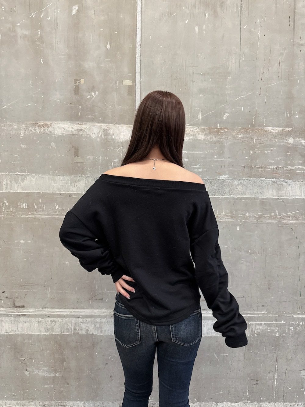 ブラック系のムートンコート、ブラック系のスウェット、ブルー系のデニムパンツを着用したレディースの秋コーディネートの6枚目の写真