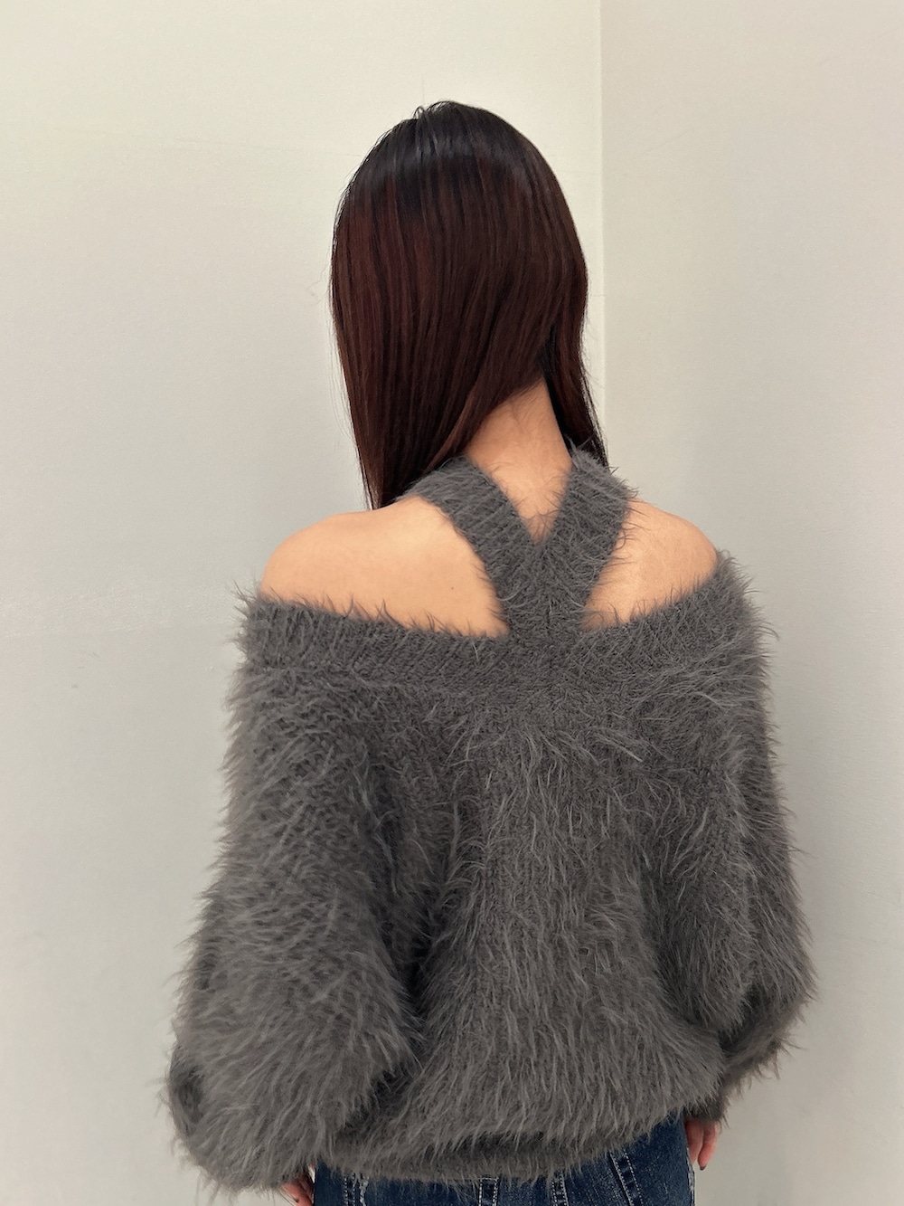 ブルー系のデニムパンツ、ブラック系のブーツ、グレー系のニット/セーターを着用したレディースの秋コーディネートの4枚目の写真
